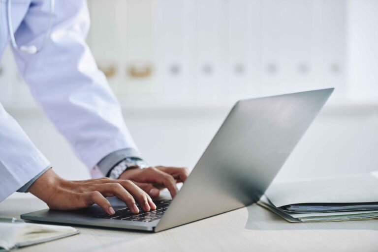 hands-unrecognizable-female-doctor-using-laptop-office-scaled-1