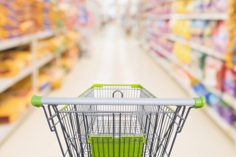 shopping-cart-with-abstract-blur-supermarket-discount-store-aisle-pet-food-product-shelves-scaled-1