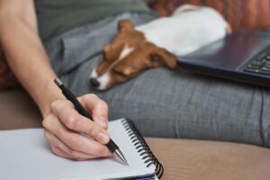 woman-write-plans-notebook-with-her-jack-rusel-terrier-puppy-dog-good-relationships-friendship-owner-animal-pet-scaled-1